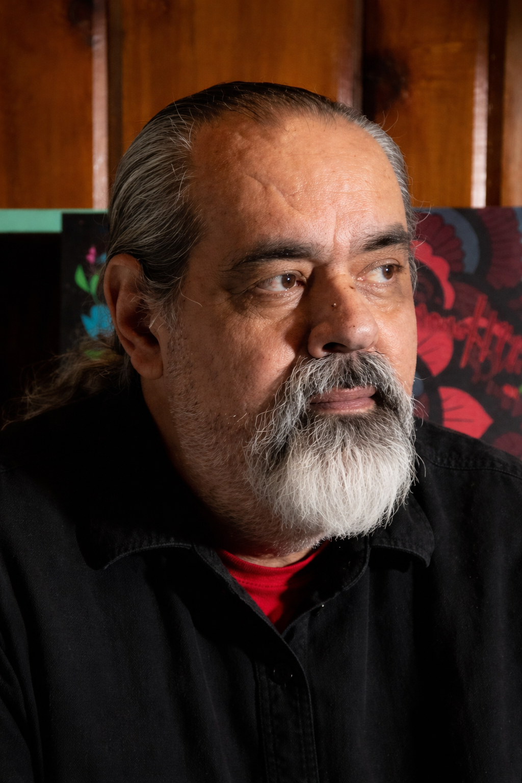 Man with graying beard and hair, indoors.