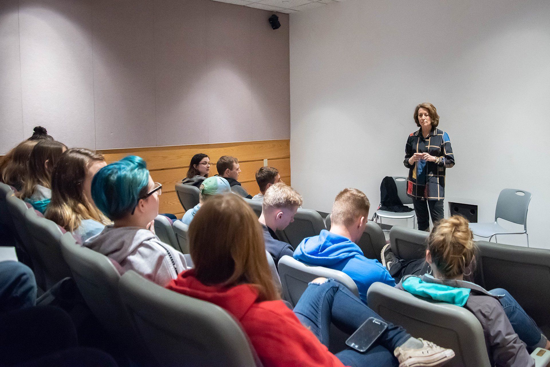 A woman is giving a presentation to a group of people in an auditorium.
