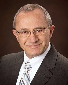 A man in a suit and tie is smiling for the camera.