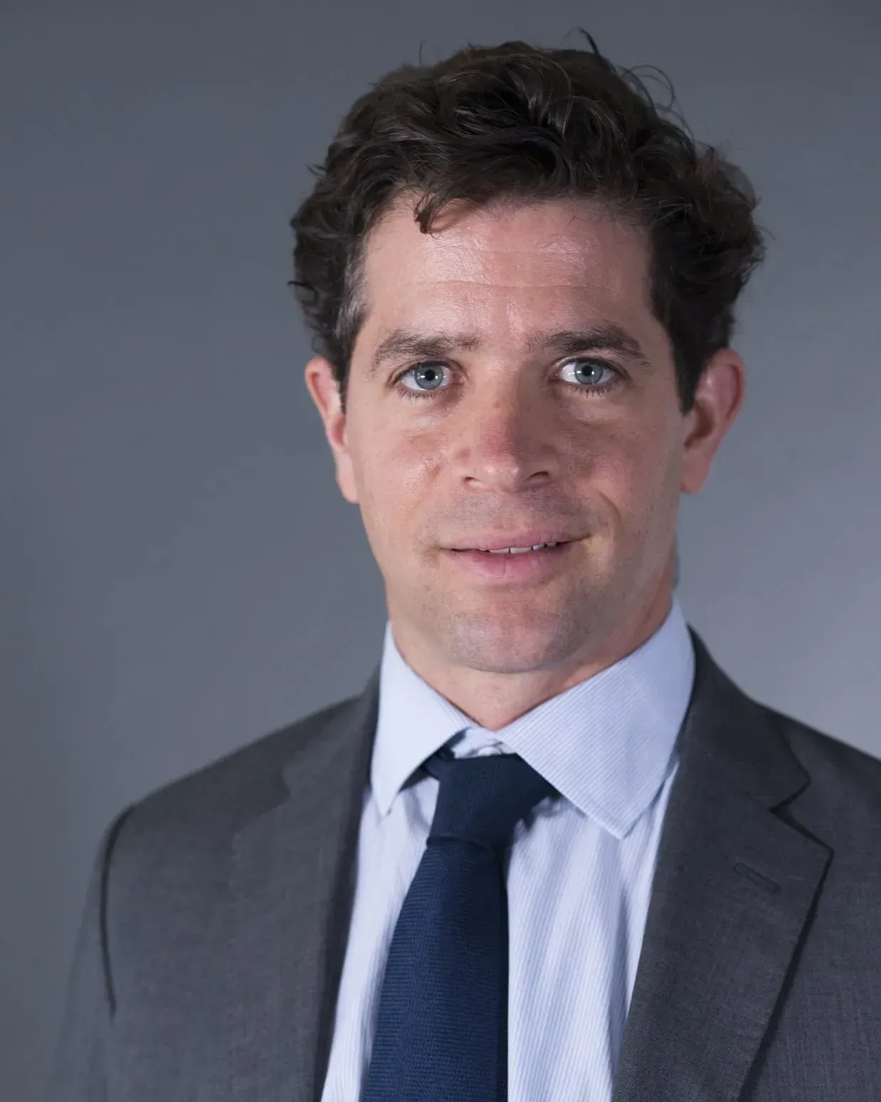 A man in a suit and tie is smiling for the camera.