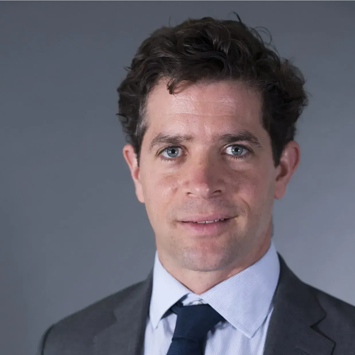 A man in a suit and tie is smiling for the camera