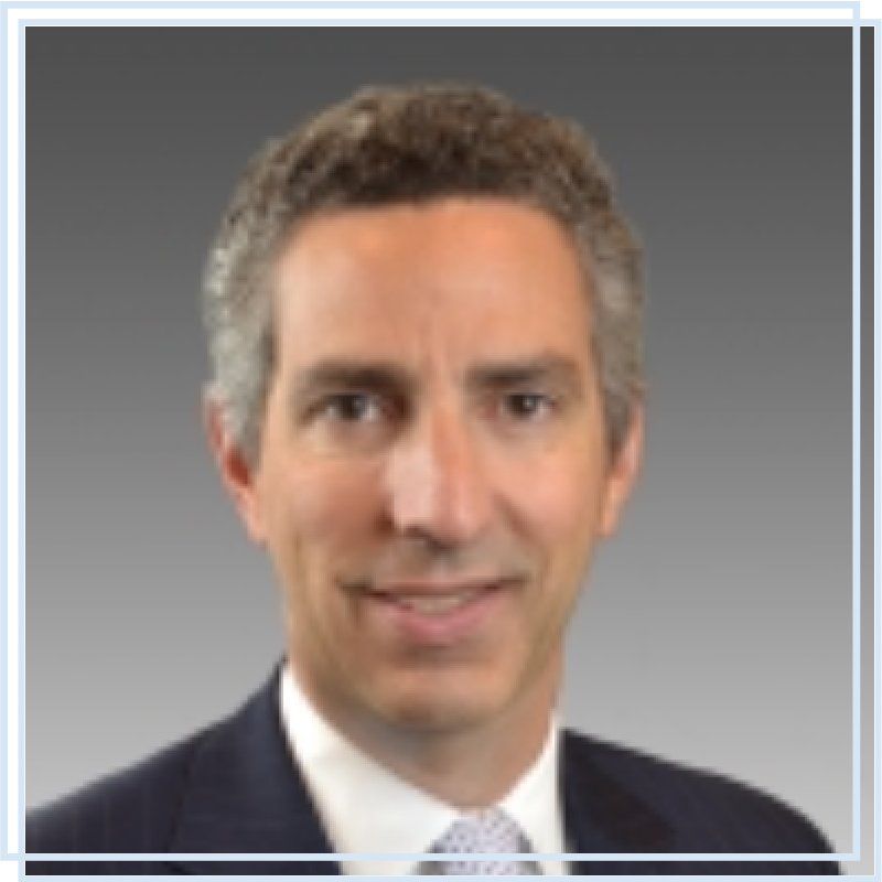A man in a suit and tie is smiling for the camera