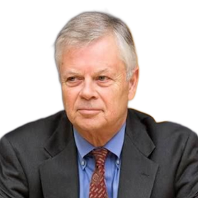 Portrait of a man in a dark suit, blue shirt, and red tie against a white background