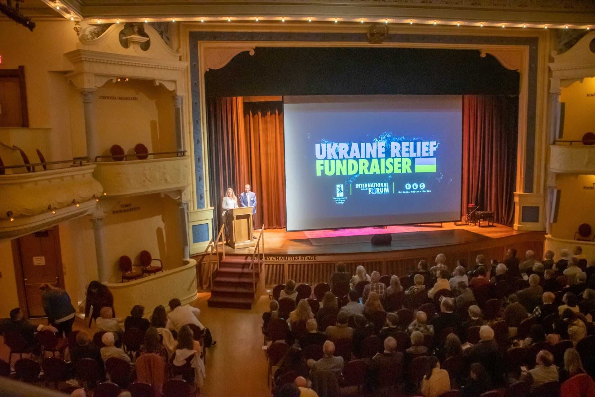 A large audience is watching a presentation about ukraine relief fundraiser