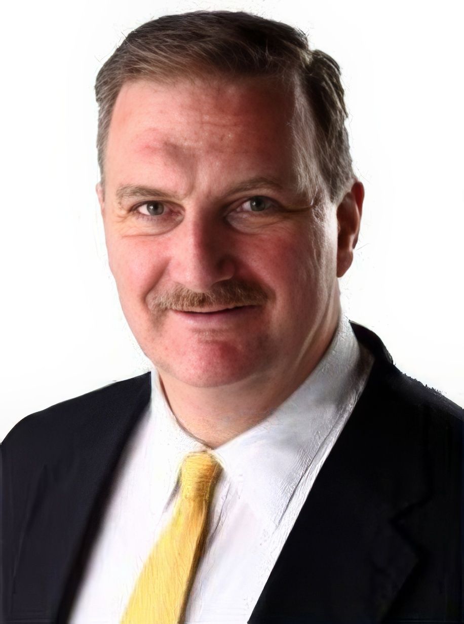 A man with a mustache is wearing a suit and tie