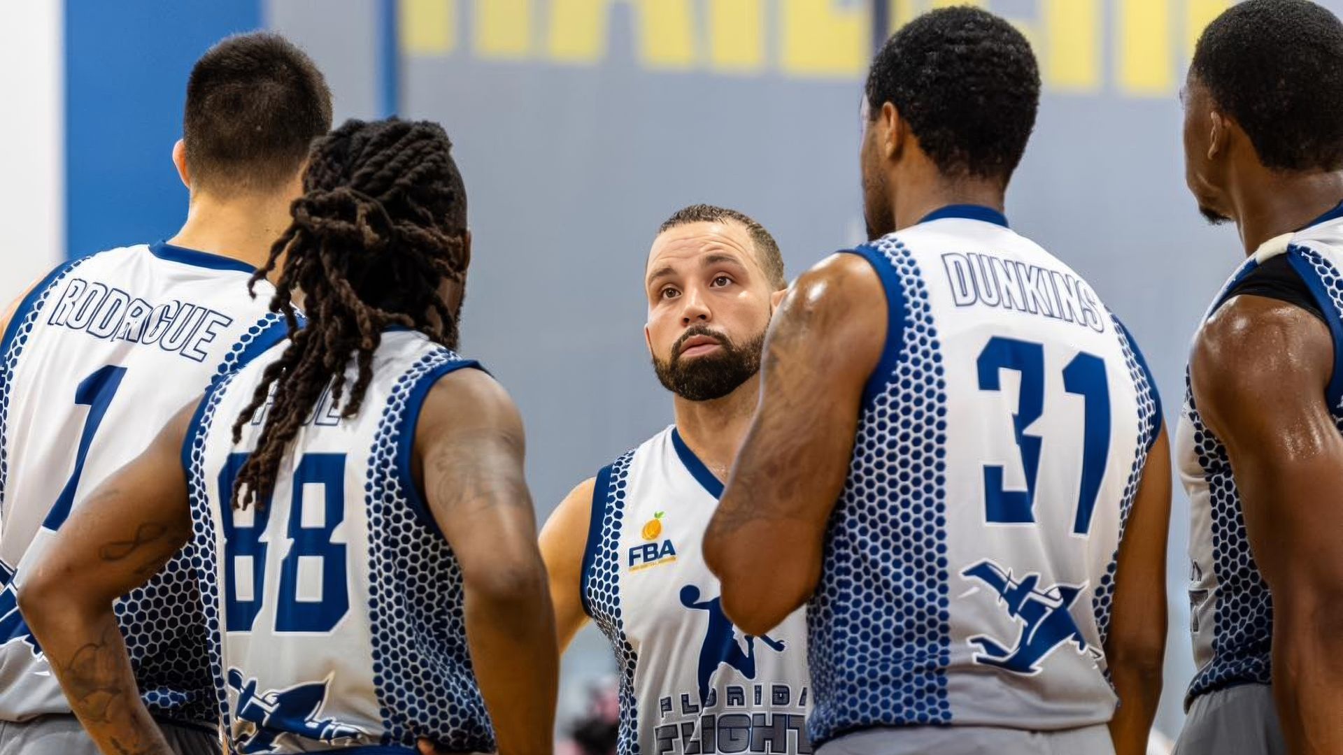A group of basketball players are standing next to each other on a court.