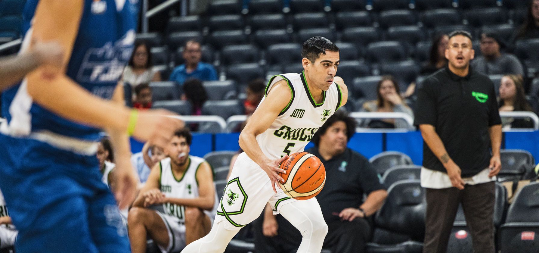 A basketball player is dribbling the ball on a court.