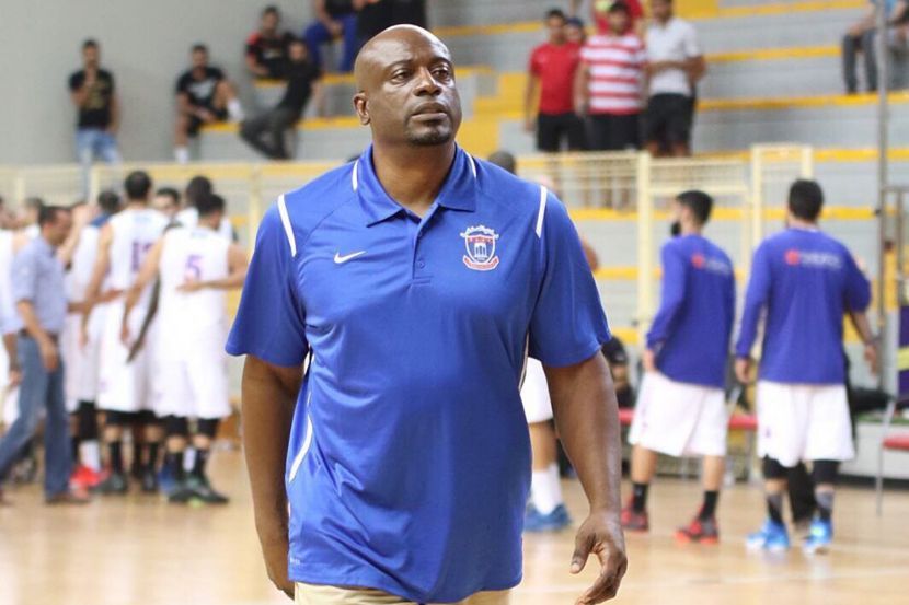 A man in a blue nike shirt is walking on a basketball court
