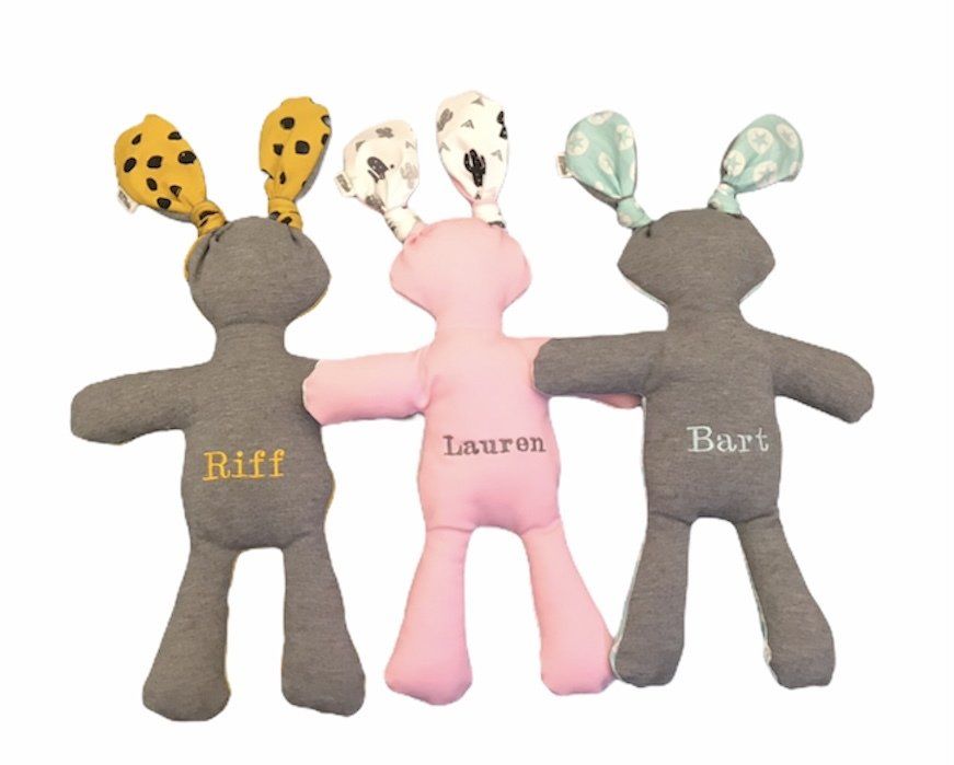 Drie knuffelkonijntjes in grijs, roze en grijs met oren met patroon en geborduurde namen.