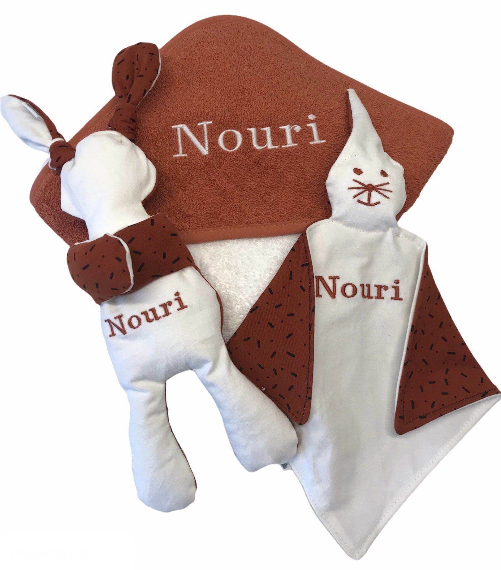 Babycadeauset met bruine, witte en bordeauxrode dekens en een pluche pop met het opschrift 