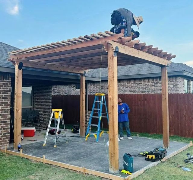 Construction of a wooden pergola in a backyard, with workers on a ladder, and tools.