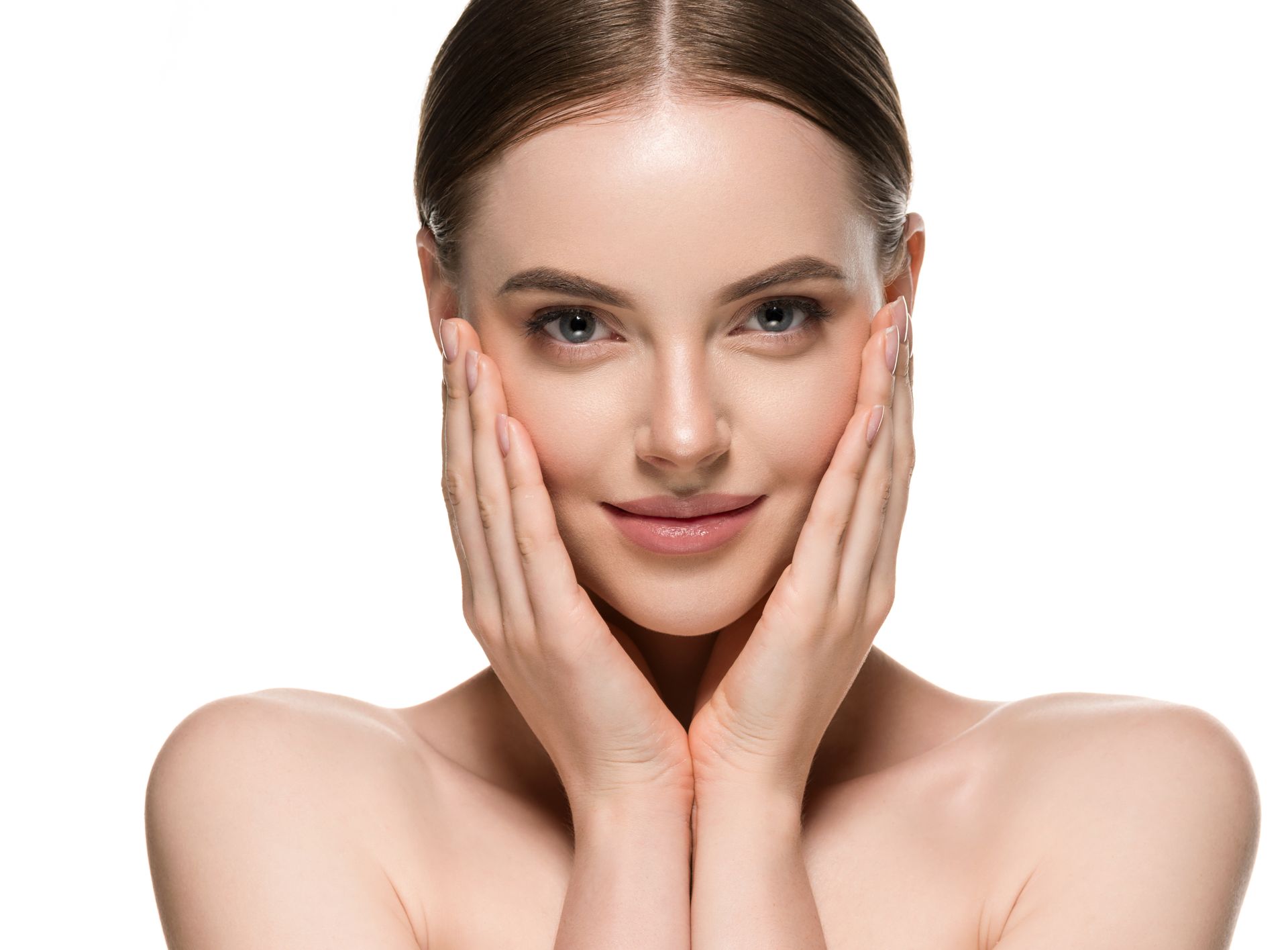 Woman with hands on her cheeks, smiling, looking at the viewer; white background.