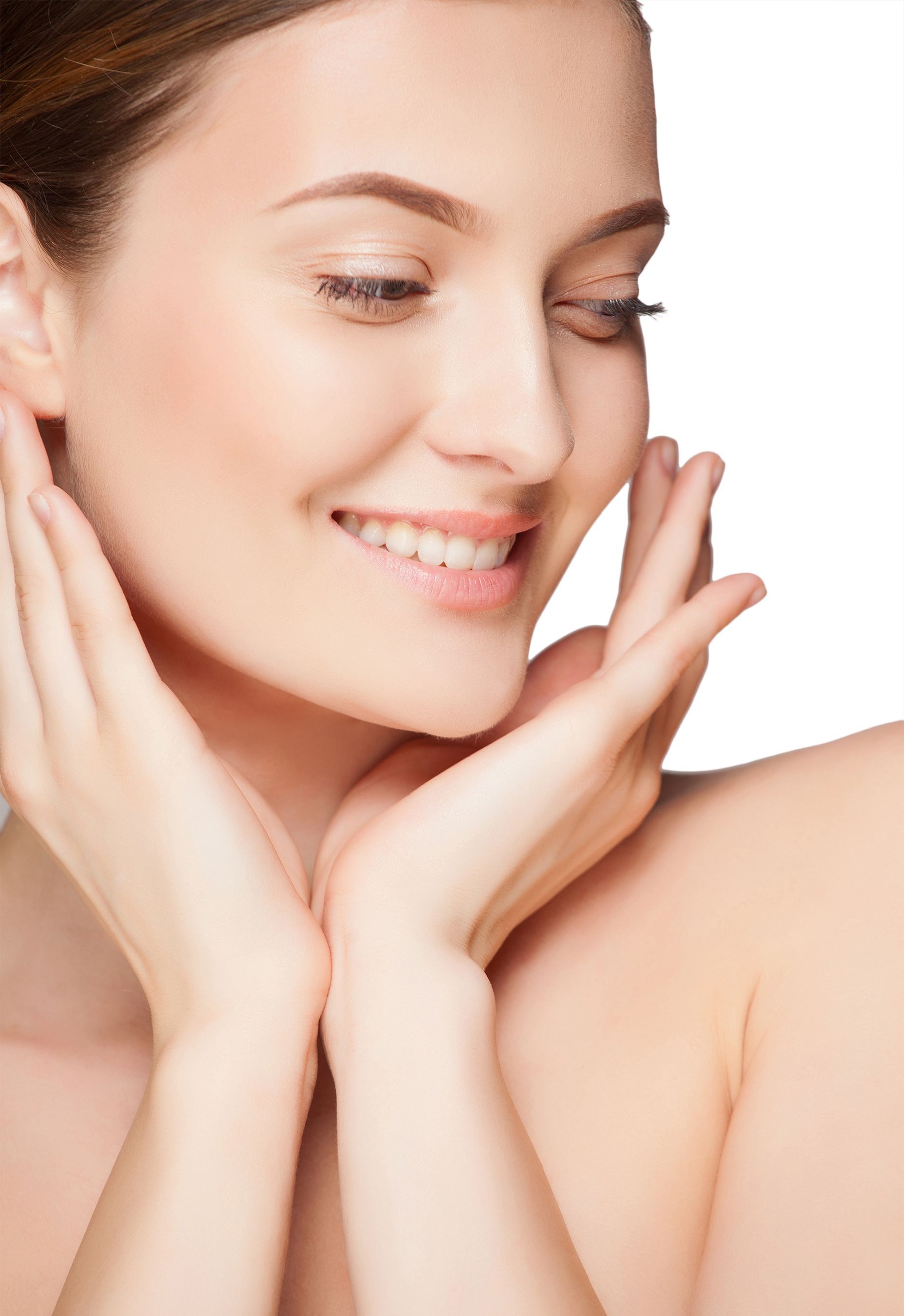 Woman smiles, touching her face with both hands, looking down.