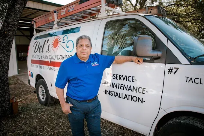 Man in blue shirt, standing by a white van with