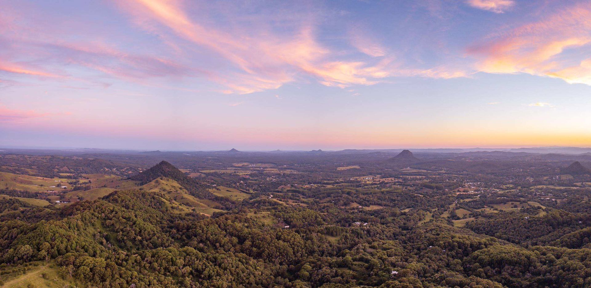 Sunrise Over A Vast Green Landscape With Distant Hills — SRV Roofing in Noosa, QLD