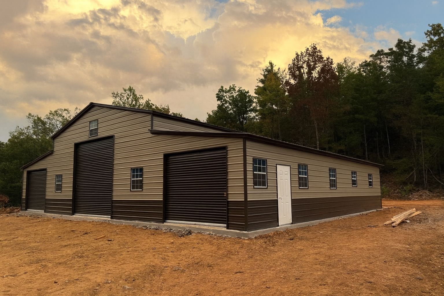 New beige and brown house under construction on a dirt lot near trees