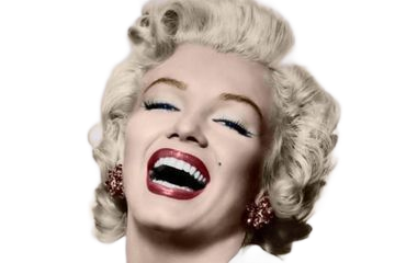 Marilyn Monroe laughing, headshot. Blonde curly hair, red lipstick, and red jeweled earrings.