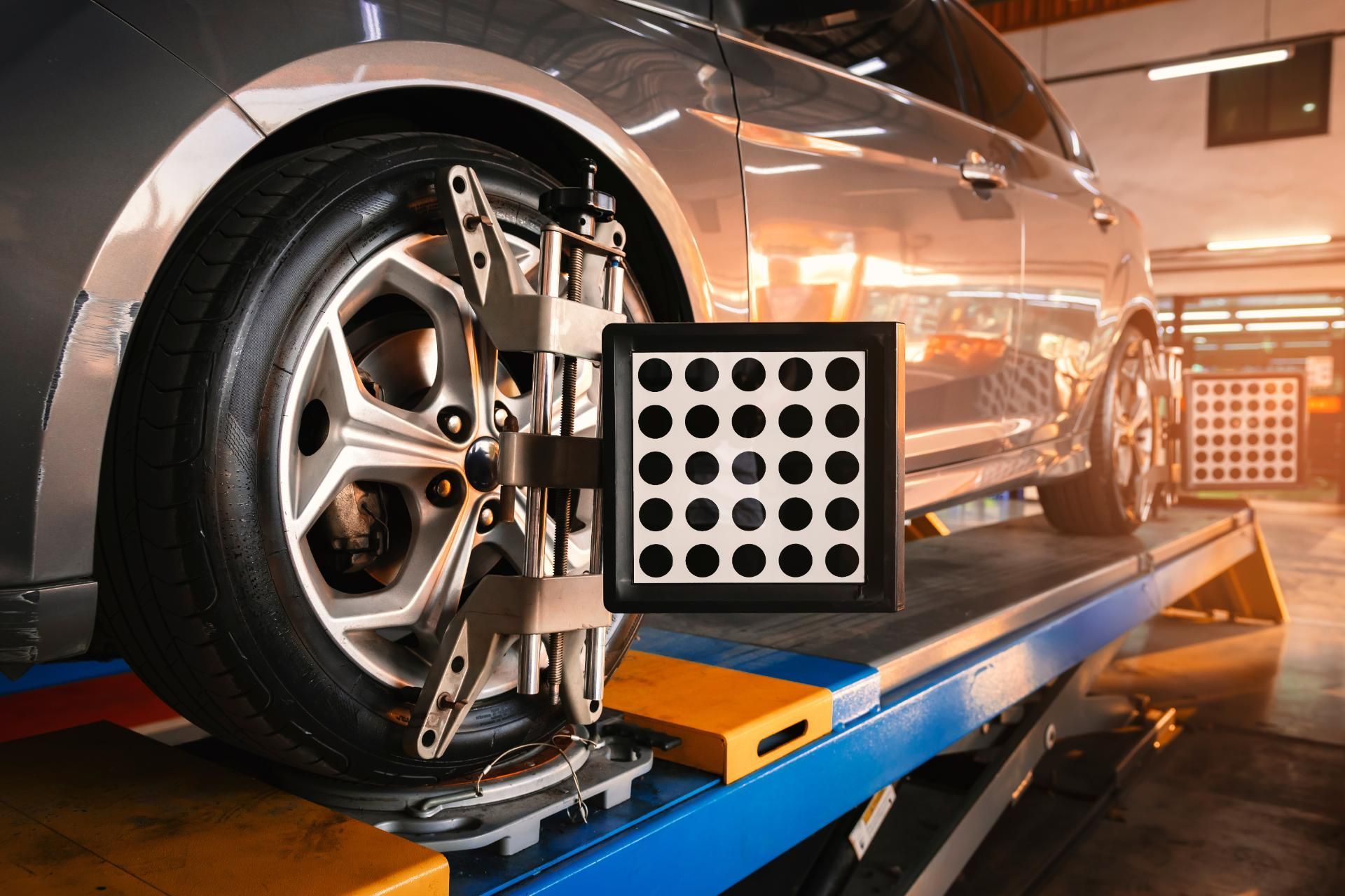 Car wheel on an alignment machine in an auto repair shop, with a measurement sensor attached