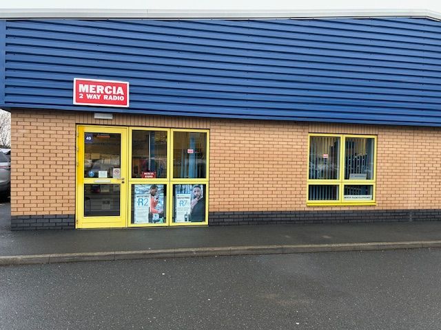 A brick building with a yellow door and a sign that says mercia
