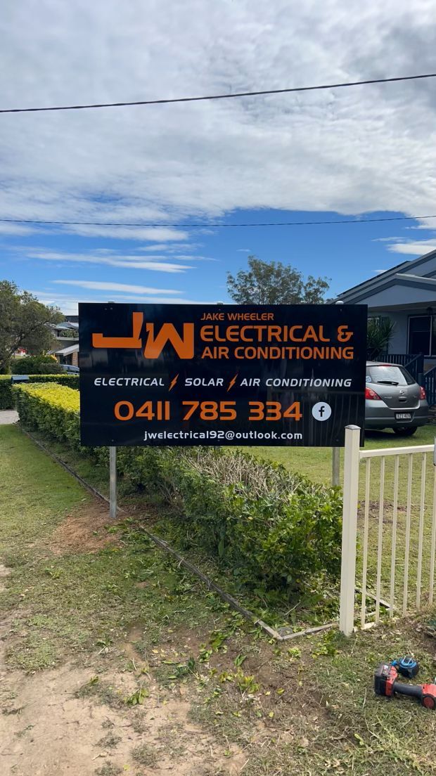 A Sign for Electrical and Air Conditioning is Sitting in Front of a House — JW Electrical, Air & Solar Pty Ltd in Kew, NSW