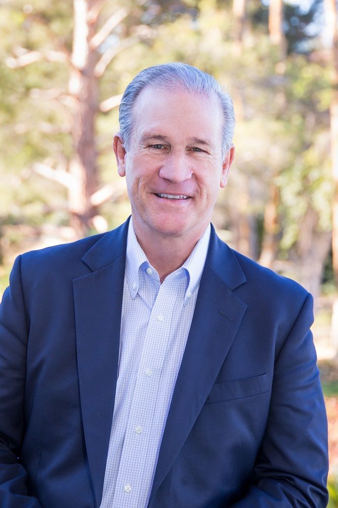 A man in a suit and tie is smiling for the camera.