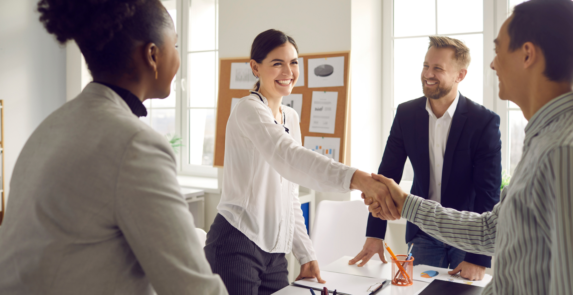 Business team shaking hands during a meeting in a bright office