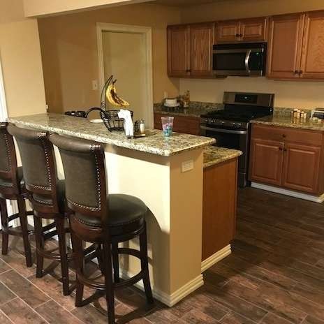 Kitchen with bar seating, stainless steel appliances, and wooden cabinets.