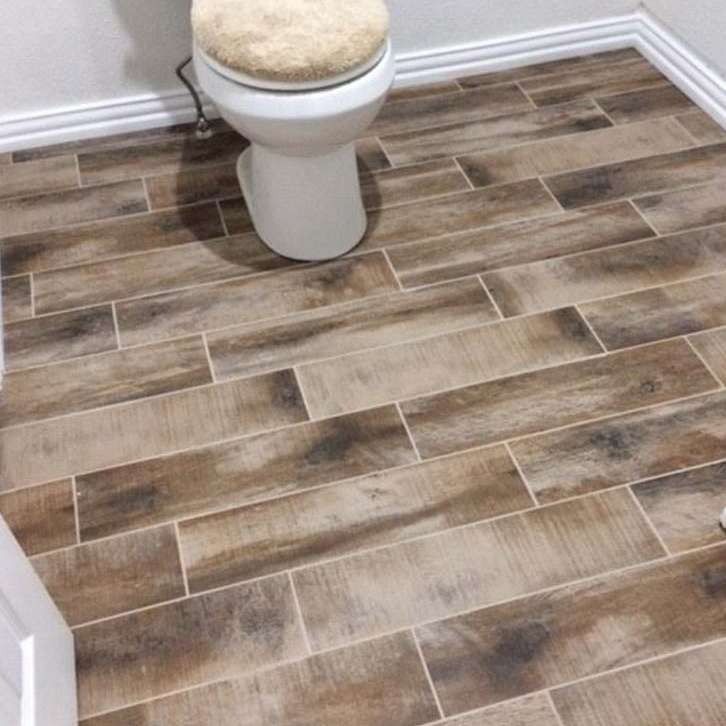 Bathroom with wooden plank-style floor tile, white toilet, and white trim.