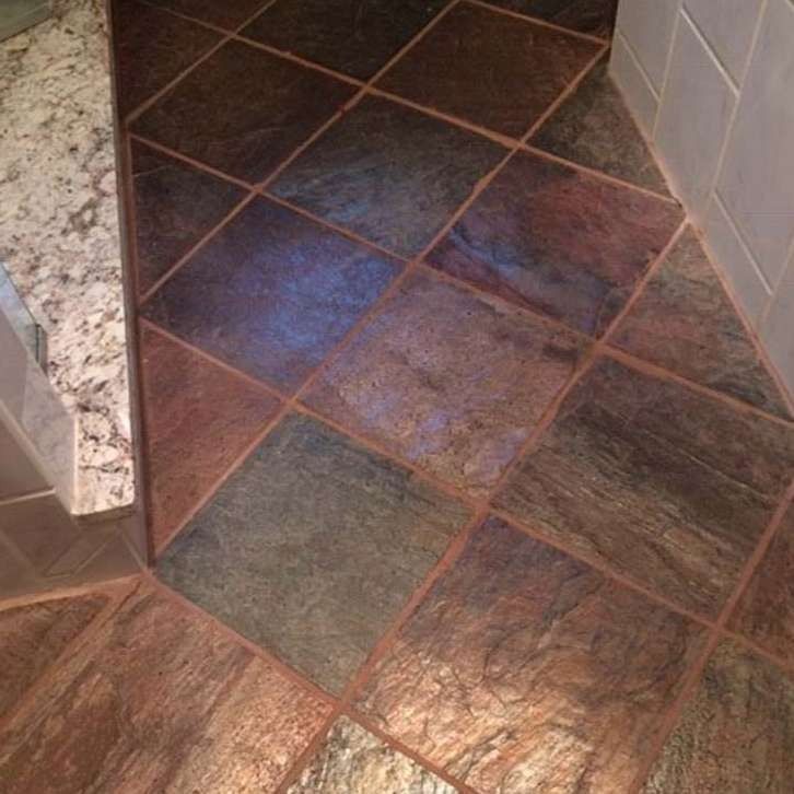 Brown and gray diamond-patterned tile floor, bordered by lighter brown tile and granite countertop.