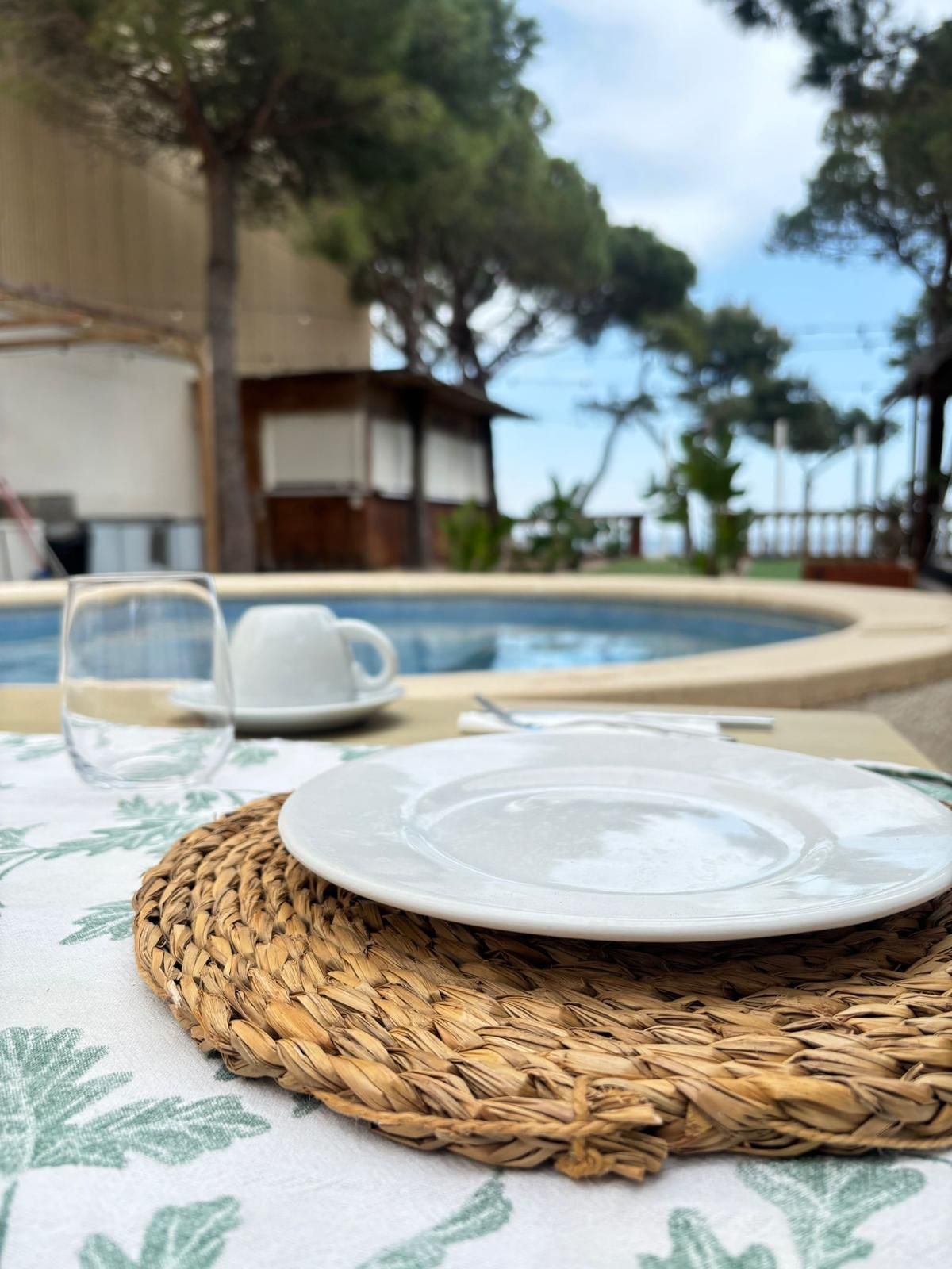 Mesa con varios platos y dos copas de vino tinto, en un ambiente cálido e informal.