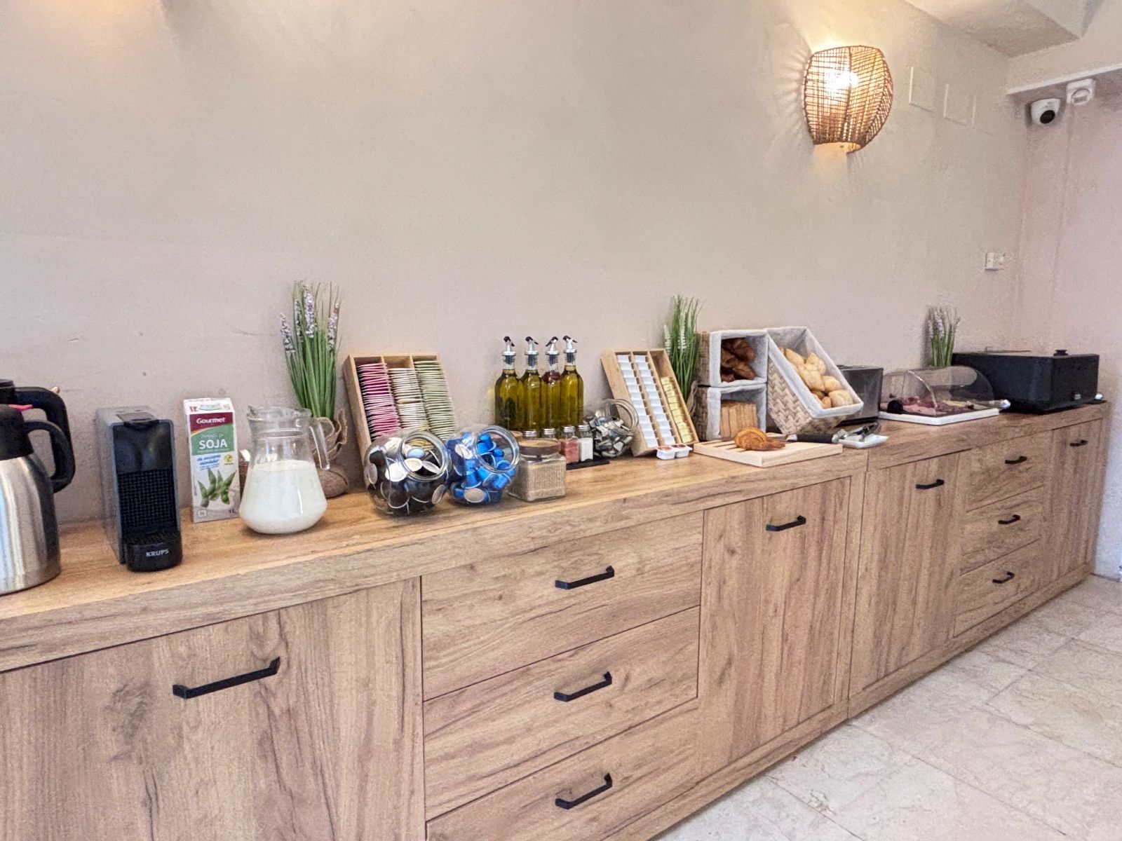 Aparador de madera con aperitivos, bebidas y adornos en una habitación luminosa