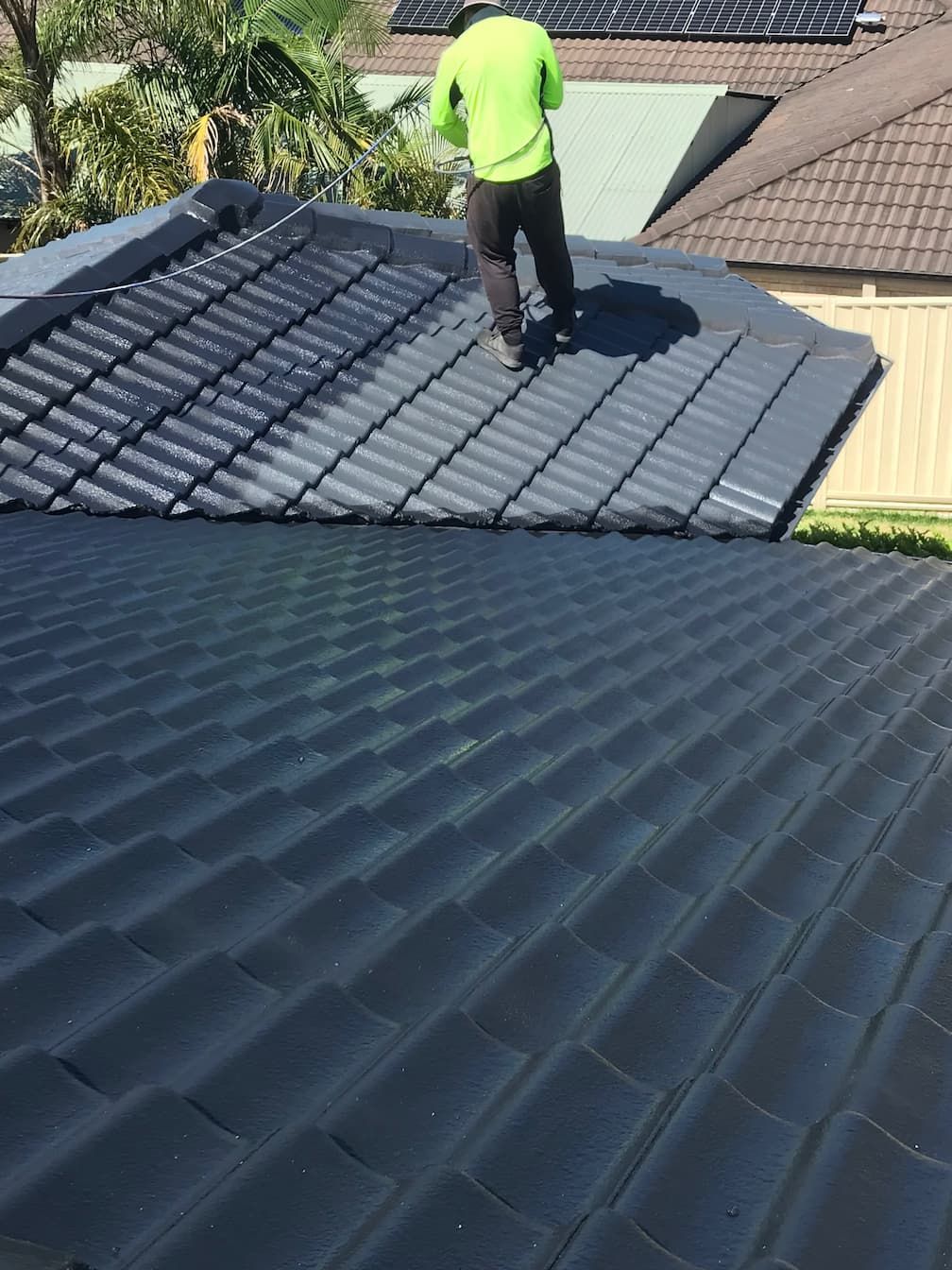 A person painting a roof in Wollongong