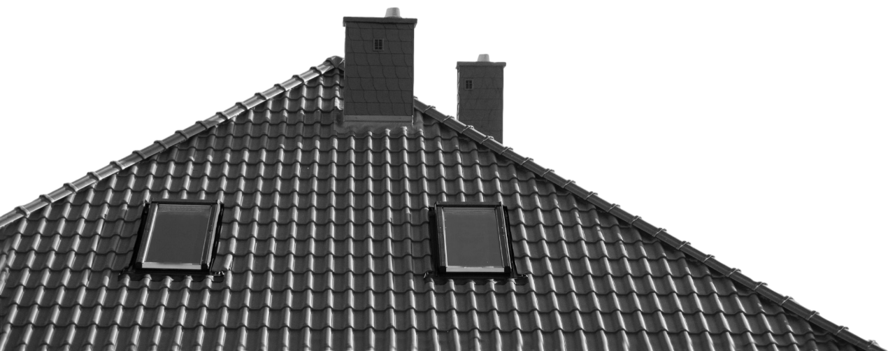 The dark, tiled roof of a house features two chimneys and two skylight windows against a plain white background.