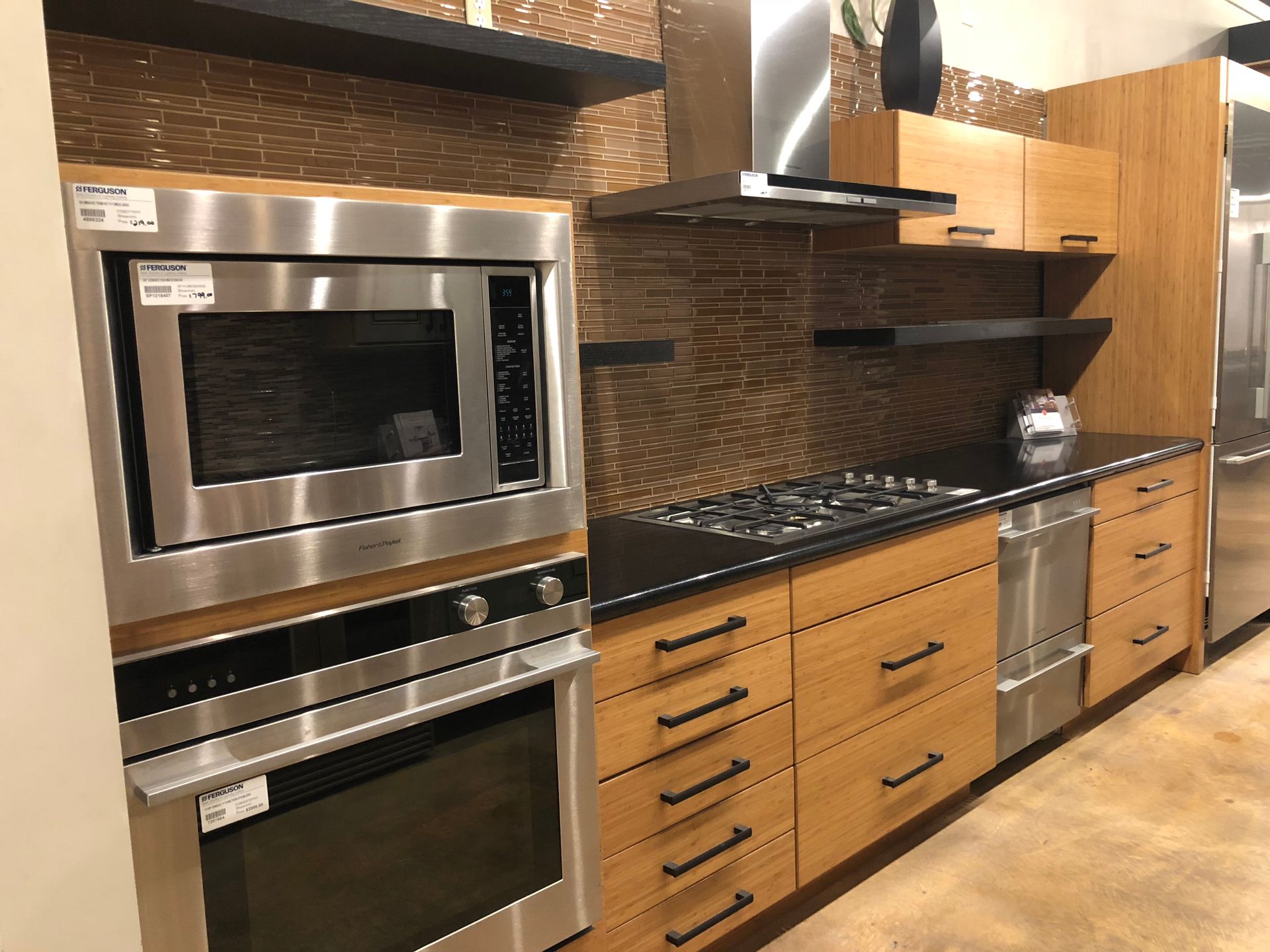 Modern kitchen with stainless steel appliances, wooden cabinets, and dark backsplash.