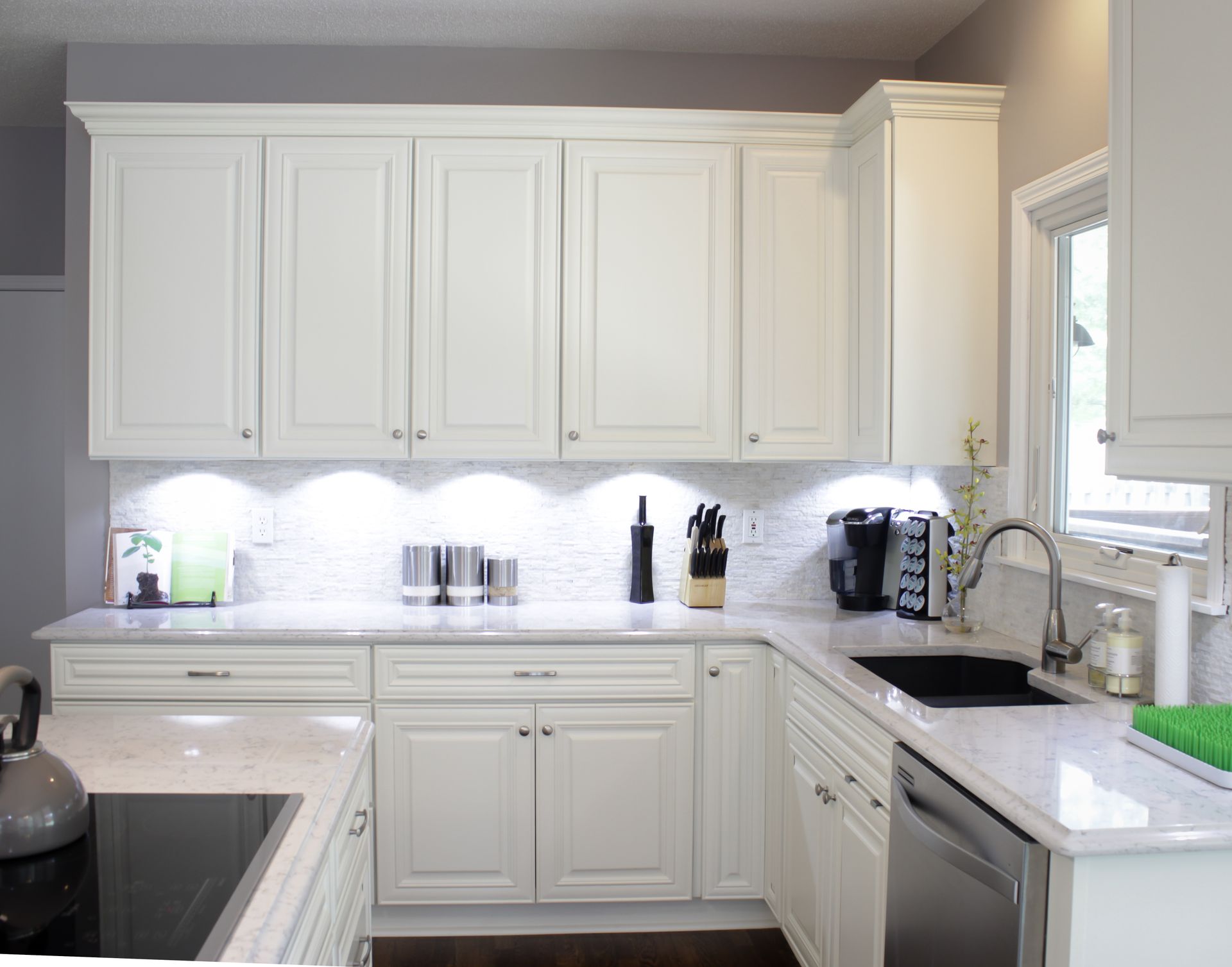White kitchen with cabinets, countertops, sink, and appliances.