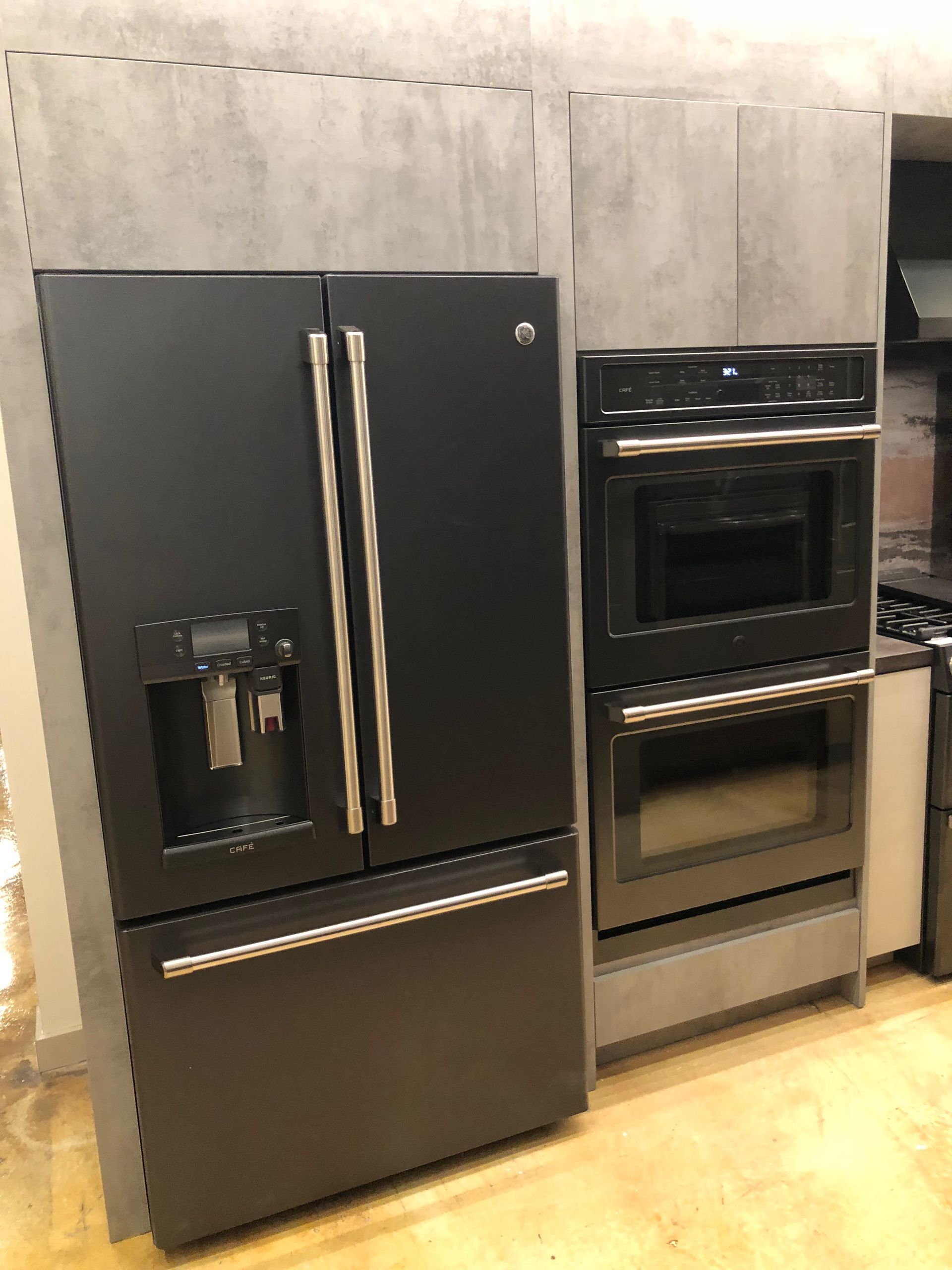 Black GE refrigerator and oven in a kitchen setting.
