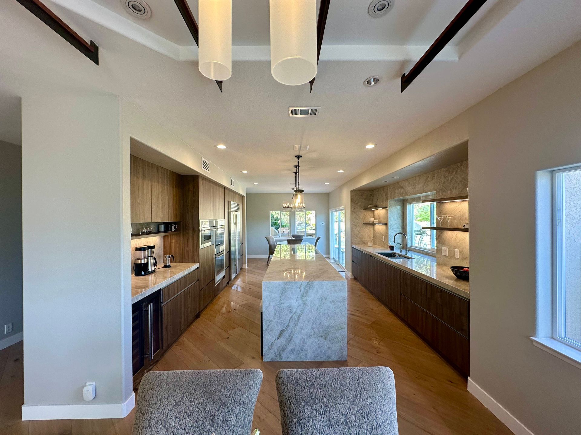 Modern kitchen with wood cabinets, island, and overhead lighting.