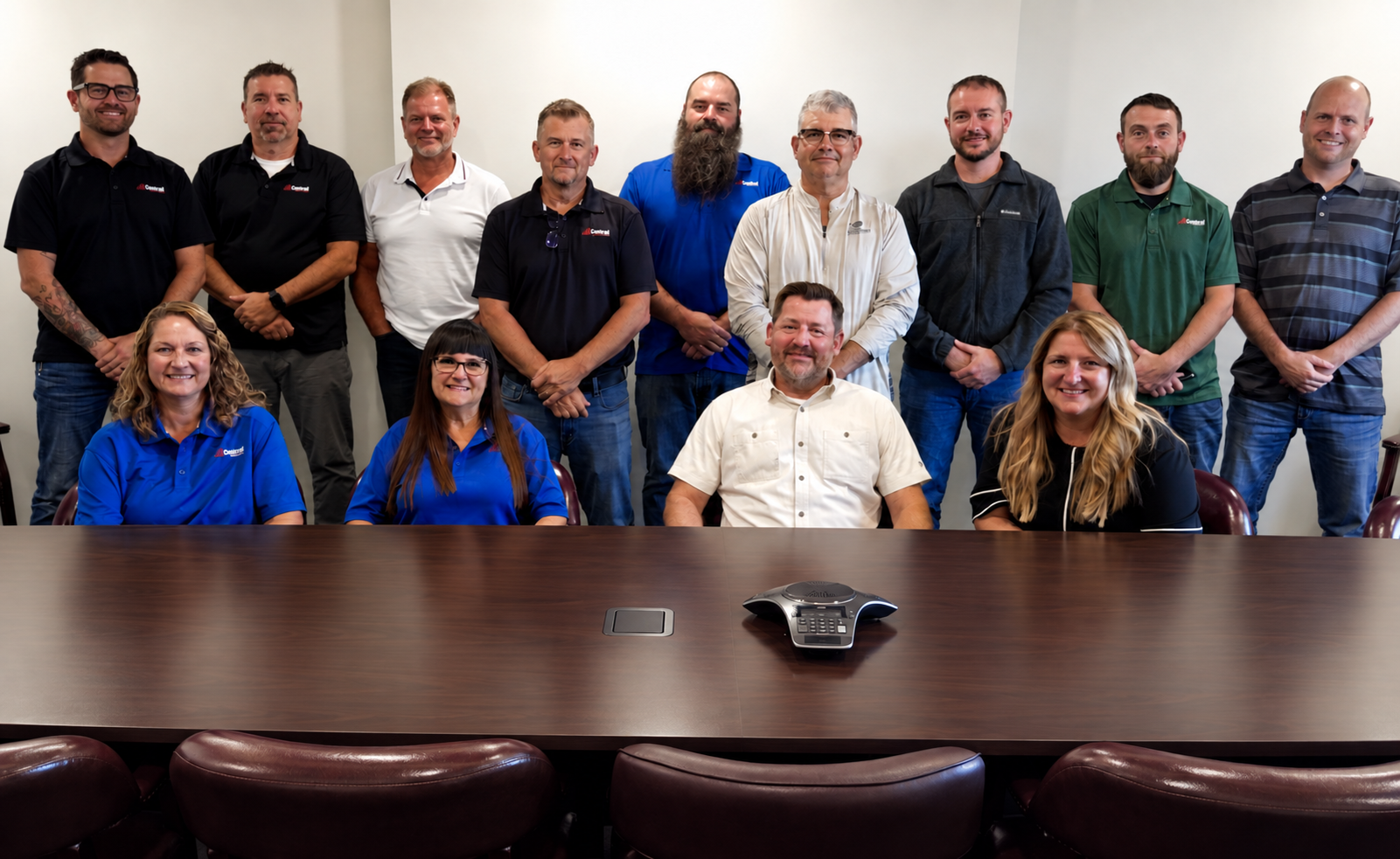 Group of people posing in a conference room behind a long meeting table