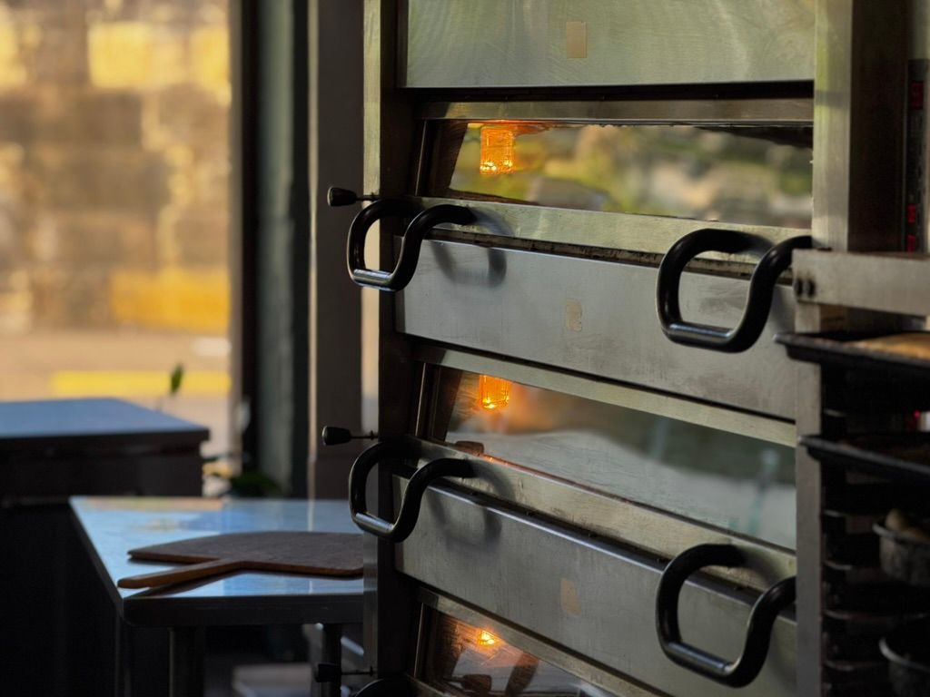 Black metal window bars beside a glass door, with warm light reflections outside.