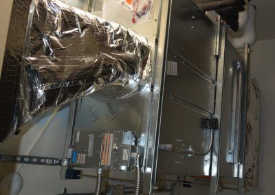 Industrial HVAC equipment wrapped in reflective insulation inside a mechanical room