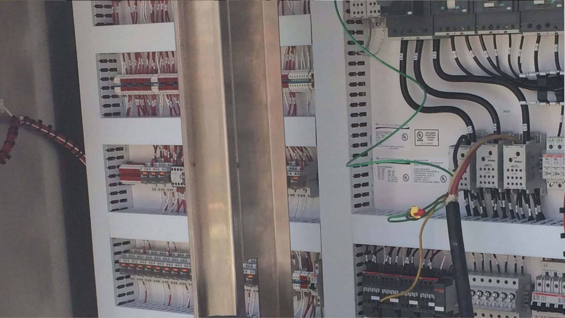 Electrical control panel with wiring, relays, and circuit components in a metal cabinet