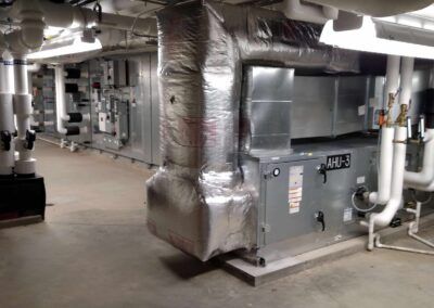 Industrial HVAC equipment and ductwork in a basement mechanical room