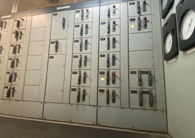 Electrical control panels with gauges and switches in an industrial room