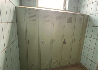 Green metal lockers in a tiled room near a window.