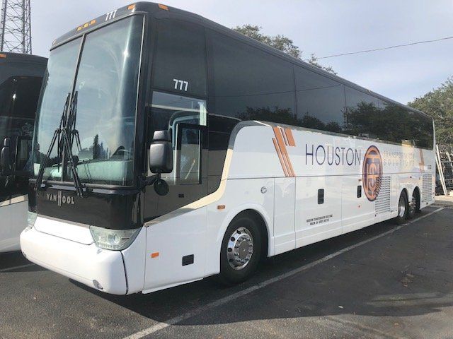 White Houston-branded coach bus parked outdoors on a sunny day