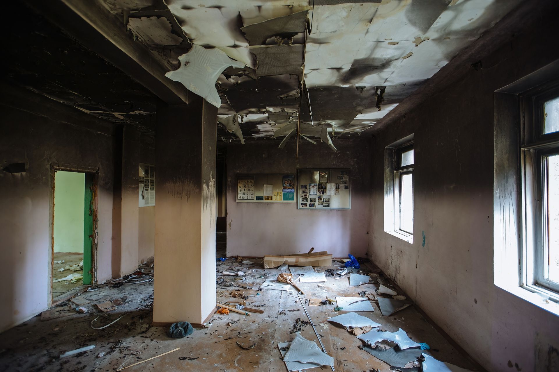 An empty room with a ceiling that has been damaged by fire.