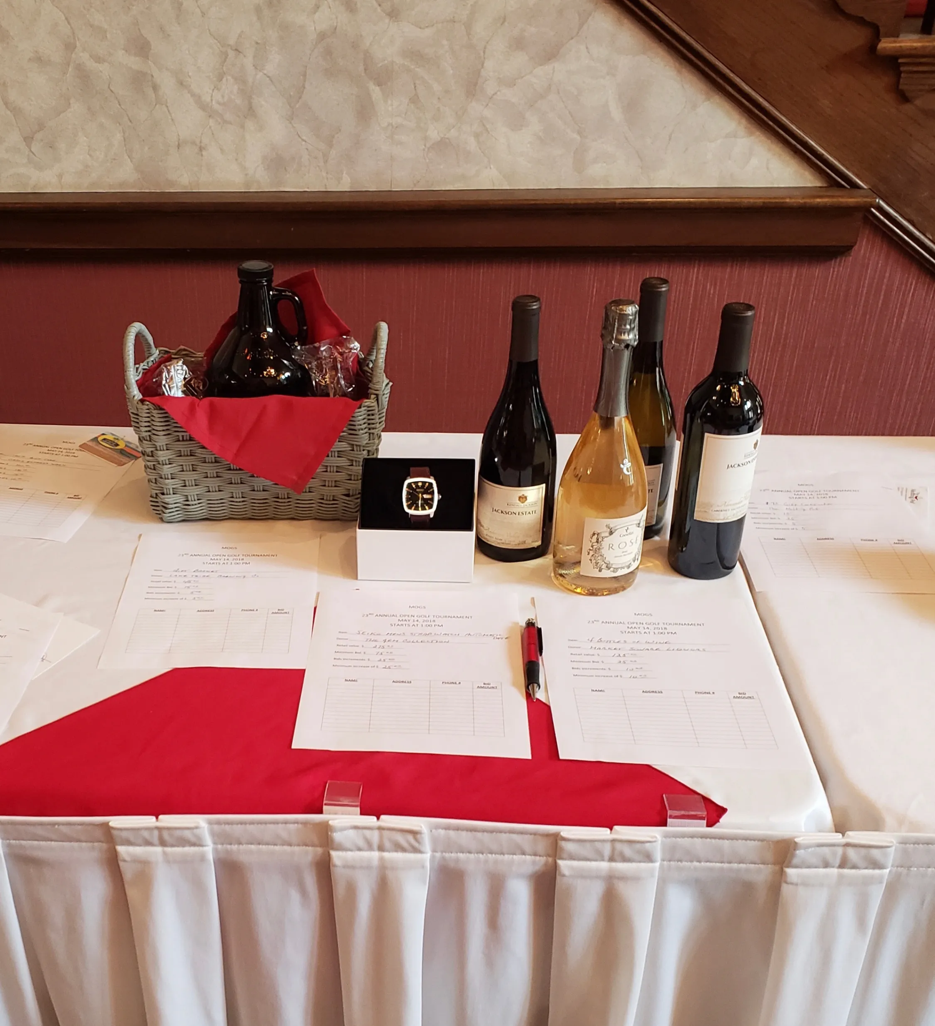 A table with bottles of wine and papers on it