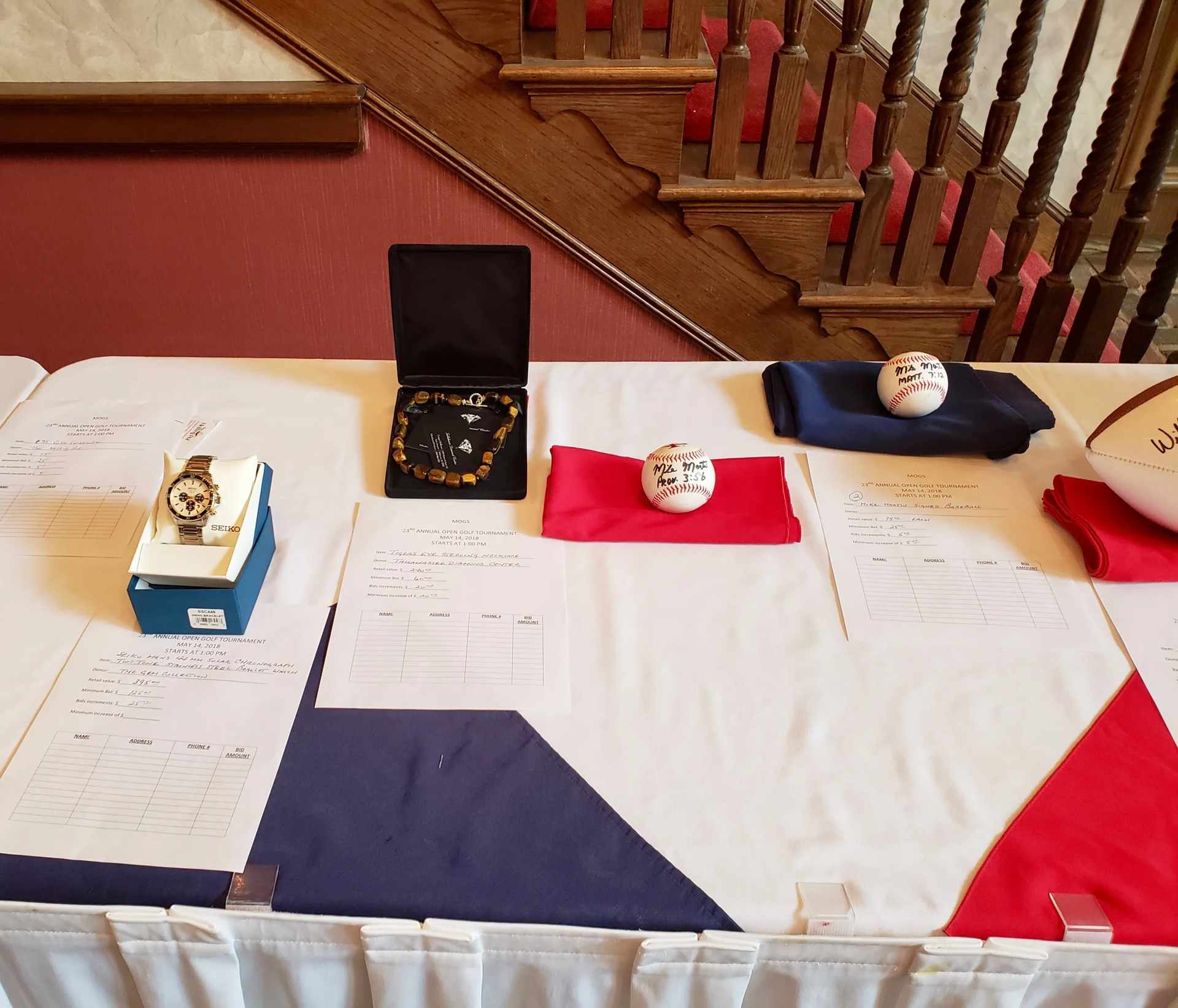 A table with a watch and a baseball on it