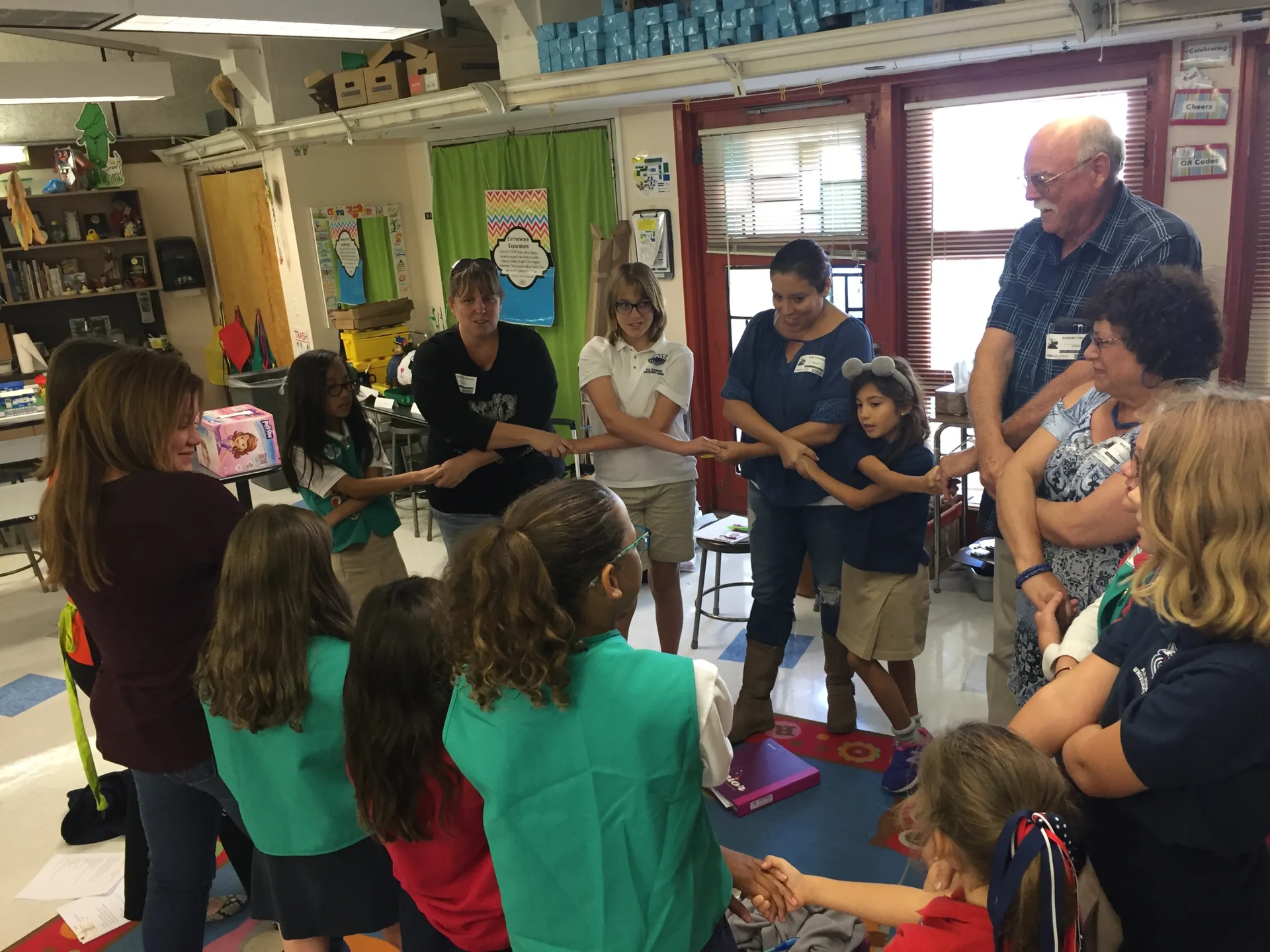A group of people are standing in a circle holding hands