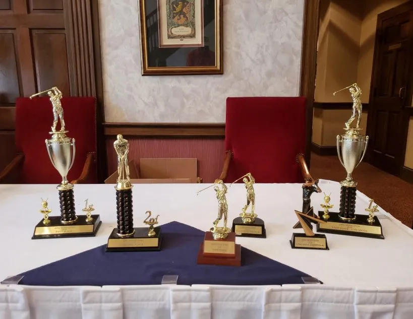 Several trophies are on a table in a room